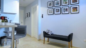 Una cocina moderna con comedor, un banco y una pared decorada con marcos.