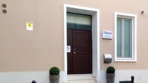 Una entrada de edificio con una puerta marrón, un buzón y un cartel que indica un negocio.