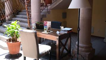 A workspace with a desk, chair, laptop, and a potted plant.