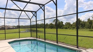 Una piscina con vistas a un campo verde y árboles.