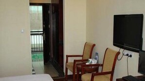 A hotel room with a bed, two wooden chairs, a desk with a computer, and a TV. - Greentree Inn Wuxi Guangrui Road Hotel (Wuxi)
