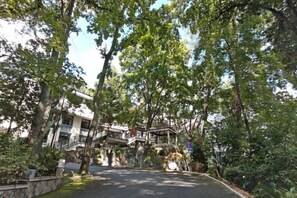 A building with a stone facade, a covered entrance, and a pathway leading to the entrance. - Wanyue Hotel (Yong'an)