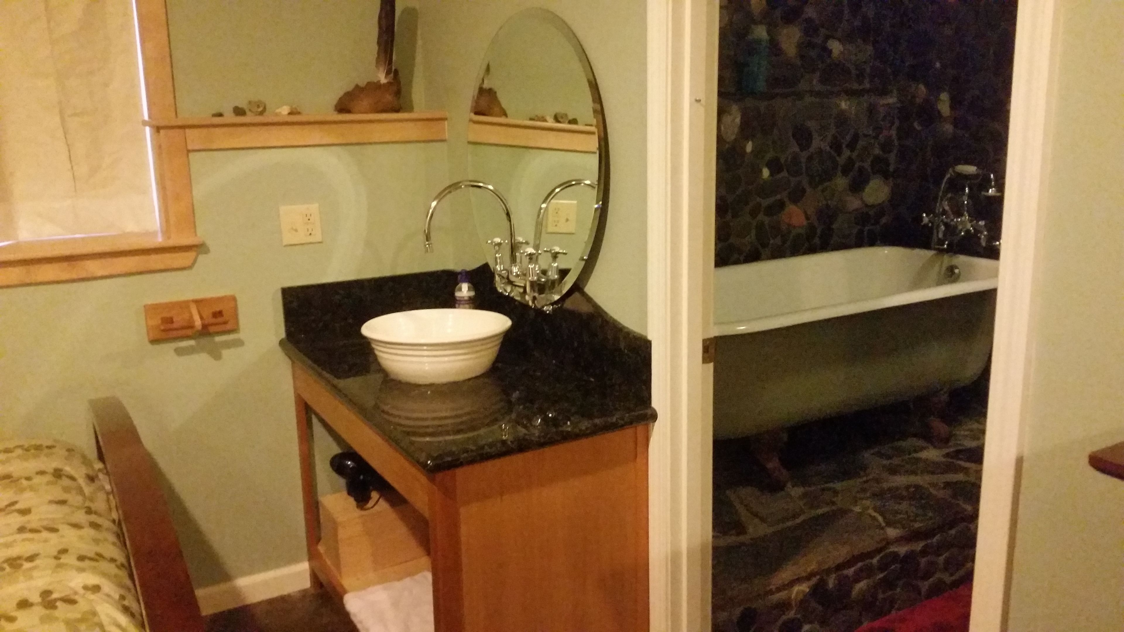 Une salle de bain avec un lavabo, un miroir et une baignoire.