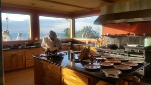 Una cocina amplia con ventanas grandes, armarios de madera y una campana extractora de acero inoxidable.