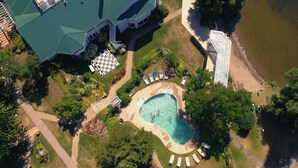 Eine Vogelperspektive eines Resorts mit Schwimmbad, Liegestühlen und einem Gebäude mit Gründach.