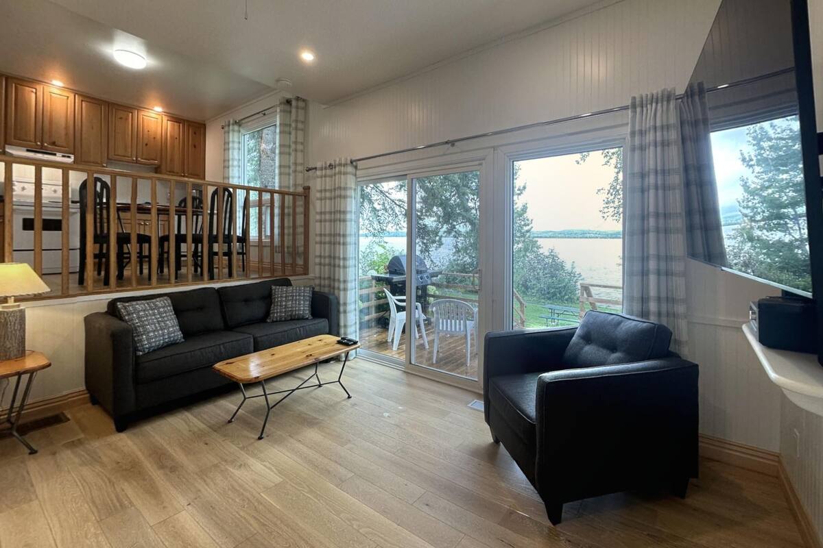 Amplia sala de estar con sofá, mesa de centro y vistas a una terraza y zona exterior.