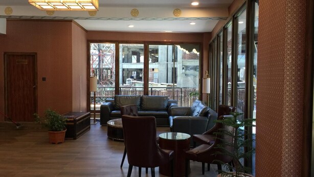 A spacious indoor area with a sofa set, chairs, and a small table. Large windows provide a view of the outside. - Bhutan Boutique Residency (Thimphu)
