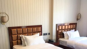 A hotel room with two beds, each with a wooden headboard and white bedding. - Bhutan Boutique Residency (Thimphu)