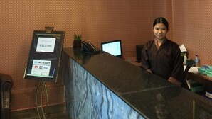 A reception desk with a modern design, a digital screen displaying 'WELCOME', and a 'WE ACCEPT' sign indicating accepted payment methods. - Bhutan Boutique Residency (Thimphu)