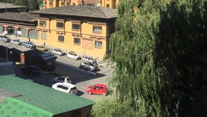 A traditional building with multiple stories and a flat roof, surrounded by lush green hills and a clear blue sky. - Bhutan Boutique Residency (Thimphu)