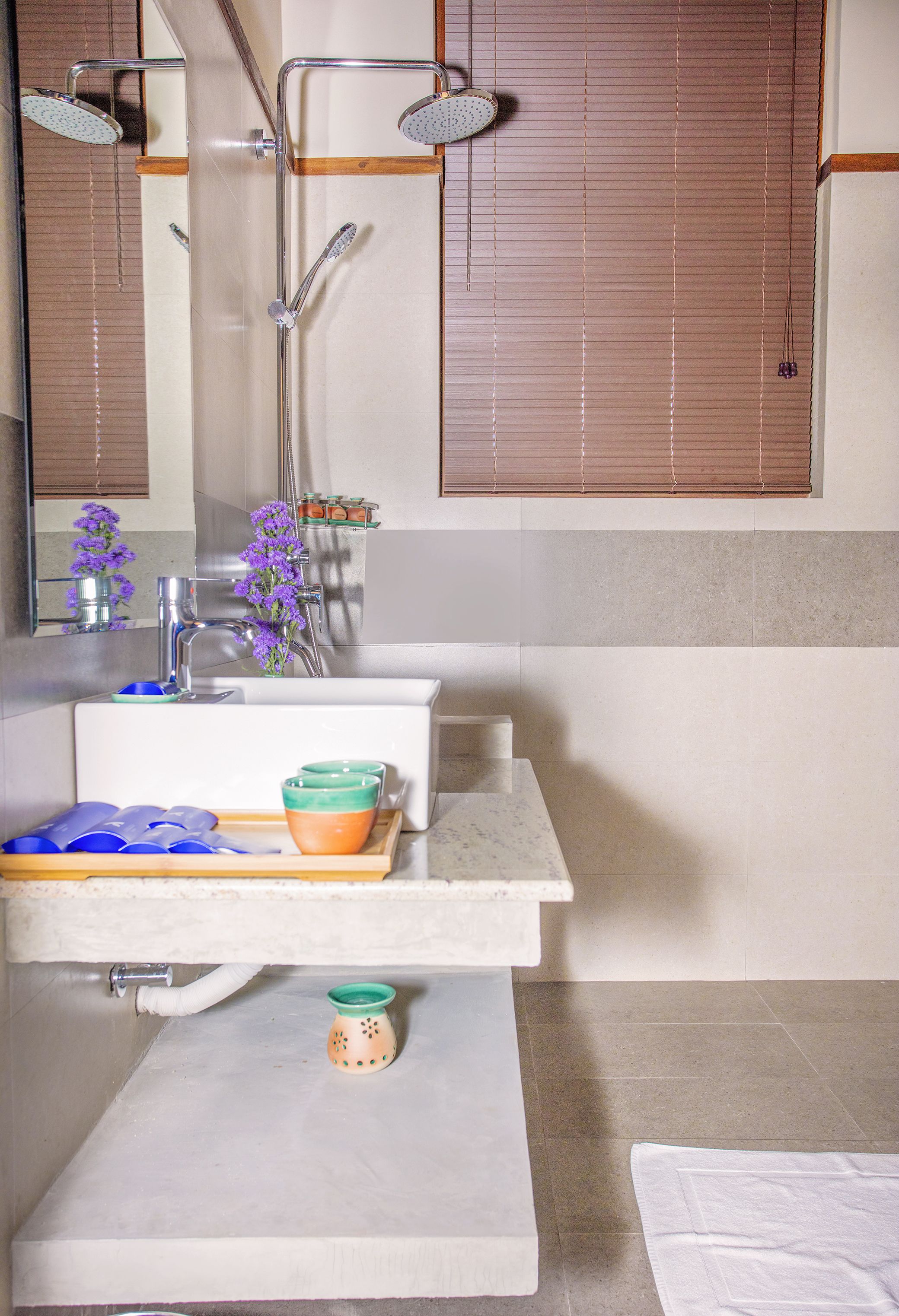 A bathroom with a sink, mirror, and shower.