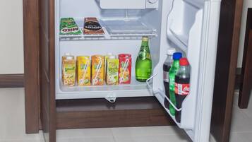 Un réfrigérateur ouvert contenant diverses boissons et collations.