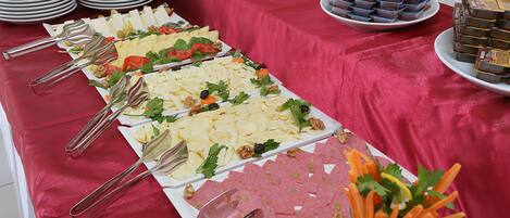 Una mesa de bufé con diversos alimentos y utensilios.