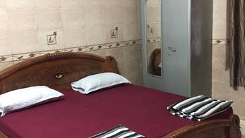 Un dormitorio con cama de madera, armario y espejo.