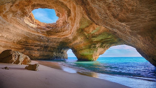 A natural rock formation with a hole, a sandy beach, and the ocean. - Casa dos Ninos (Silves)