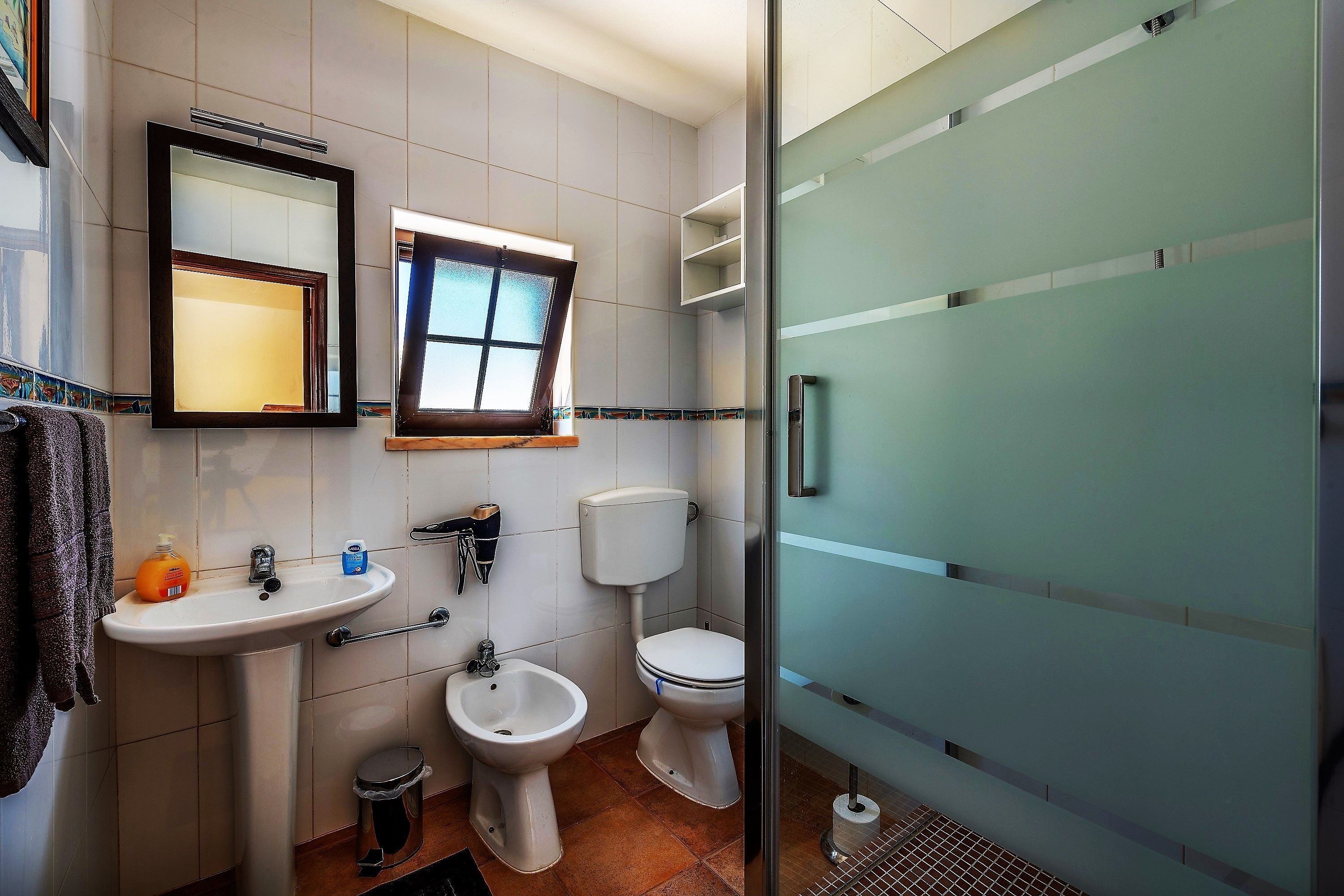 Une salle de bain moderne équipée d’un lavabo, d’un bidet, de toilettes et d’une douche à parois de verre.