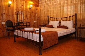 A wooden-paneled room with a single bed, a chair, and two wall-mounted lamps. - Nitsa (Tbilisi)
