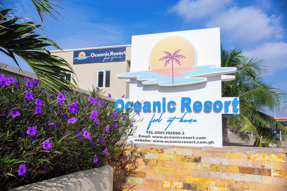 A sign for Oceanic Resort with contact information and a website URL.
