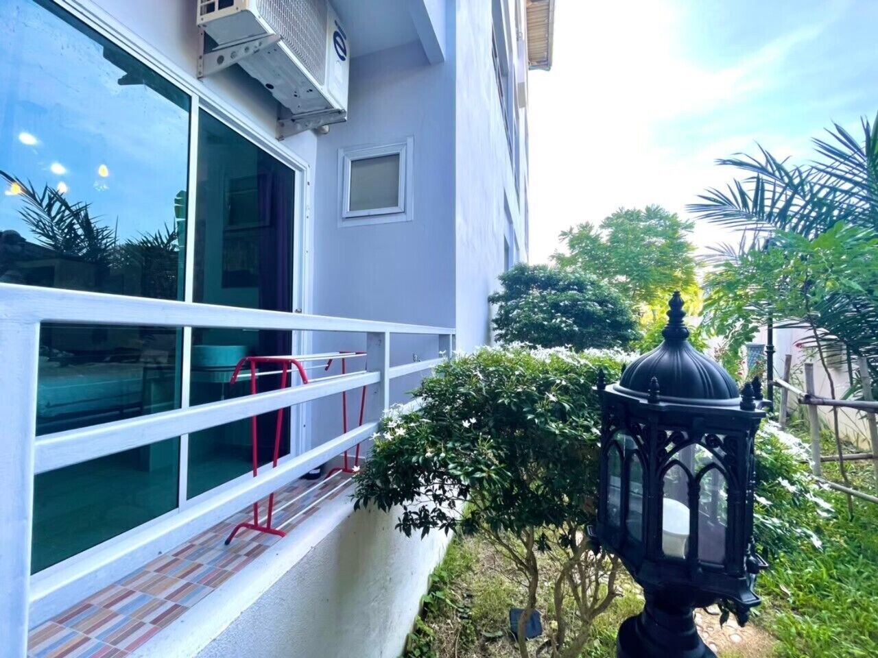A building with large windows, a red railing, and a black lantern.