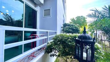 A building with large windows, a red railing, and a black lantern.