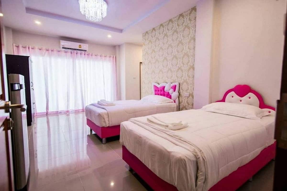 Habitación de hotel con dos camas, una araña y una ventana con cortinas.