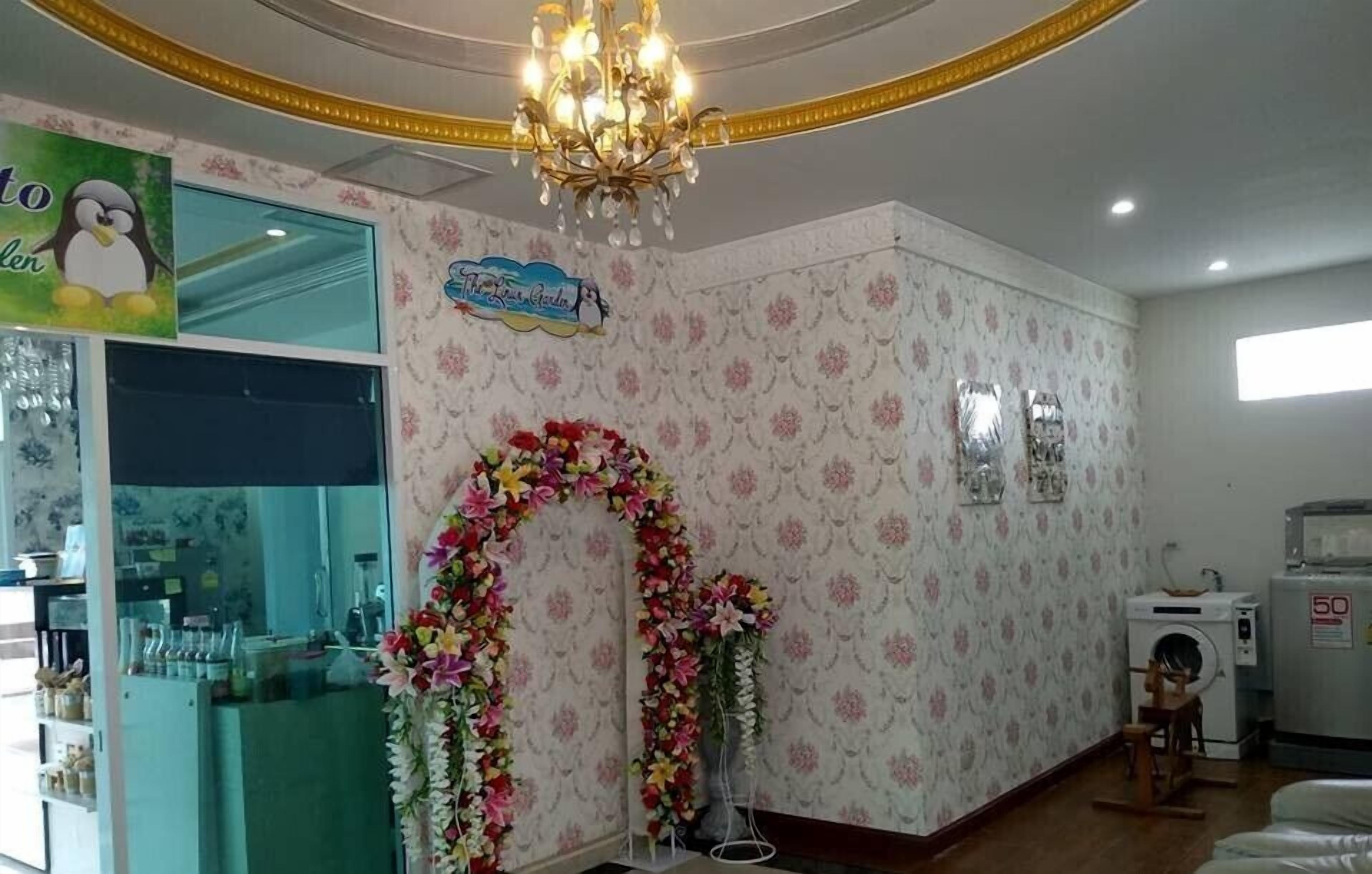 Habitación con adornos florales, un candelabro, una lavadora y un letrero con un pingüino.