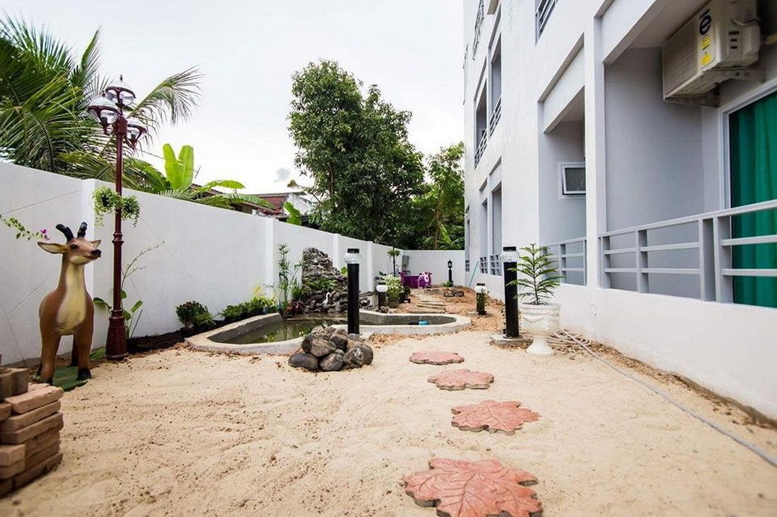 A courtyard with a small pond, stepping stones, and a statue.