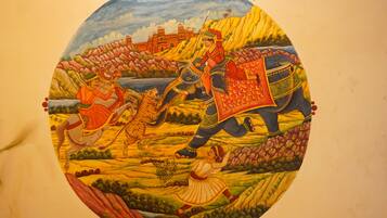A circular mural with a warrior on an elephant, a woman, and a tiger.
