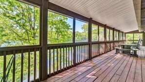 A covered wooden deck with a view of a river and trees. - 3 Bedrooms, 1 Flex Room, 3 Bathrooms!  Hot Tub, Wifi & Pet Friendly!  Great Getaway For Any Season! (Huddleston)