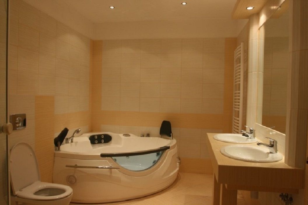 A bathroom with a bathtub, two sinks, and a toilet.