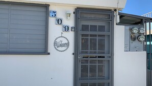 Un bâtiment doté d’une grille métallique, de panneaux numérotés, d’une enseigne d’accueil et de boîtiers électriques.