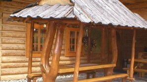 Eine rustikale Holzhütte mit geneigtem Dach und einer Bank davor.