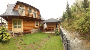 A log cabin with a balcony, a stone pathway, and a small garden. - Chaty Josu Zuberec (Zuberec)