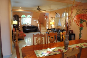 Relax in this inviting living area with a dining table for two, comfortable sofa, and cozy chair.