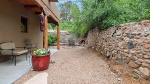 A patio area with stone walls, outdoor furniture, and a fire pit. - Clean and Comfortable, Walk to The Plaza, Ft Marcy (Santa Fe)