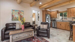 A modern living room with a leather sofa, a coffee table, and a painting on the wall. - Clean and Comfortable, Walk to The Plaza, Ft Marcy (Santa Fe)