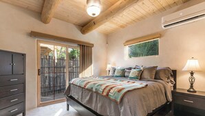A bedroom with a bed, a nightstand, a dresser, a sliding glass door, and an air conditioning unit. - Clean and Comfortable, Walk to The Plaza, Ft Marcy (Santa Fe)