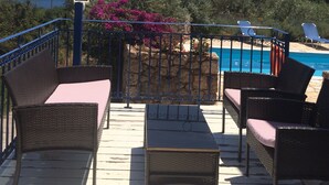 A terrace with wicker furniture, a pool, and a view of the sea. - Villas Lidia - Fengari (Livadi)