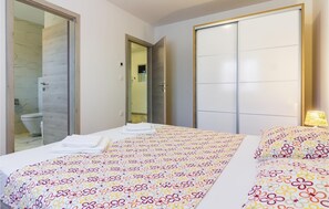 Una habitación de hotel con cama, baño y armario.