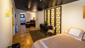 A modern hotel room with a bed, a desk, a chair, a small table with a plant, and a TV in the background. - Downtown Cozy Condo- Walk to Best Diners, Breweries, NAU, Historic Flagstaff! (Flagstaff)