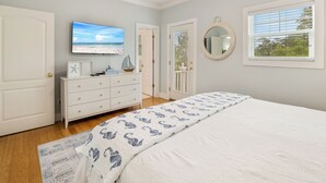Una camera da letto con un letto, una cassettiera, una televisione e una finestra con persiane.