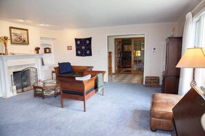 Ein Wohnzimmer mit Kamin, einer Couch, einem Couchtisch und einer Lampe.