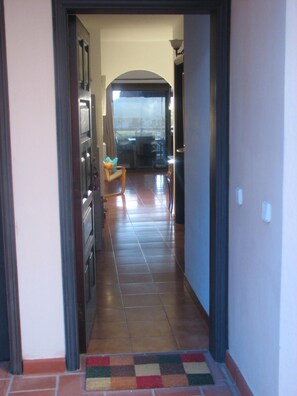 A hallway leading to a dining area with a view of the outdoors.