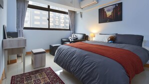 Un dormitorio moderno con una cama grande, un escritorio, una silla y una ventana con cortinas.