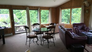 A cozy room with a wooden interior, a dining table with chairs, a leather sofa, and a bench. - Private Chalet with a View (Geneva)