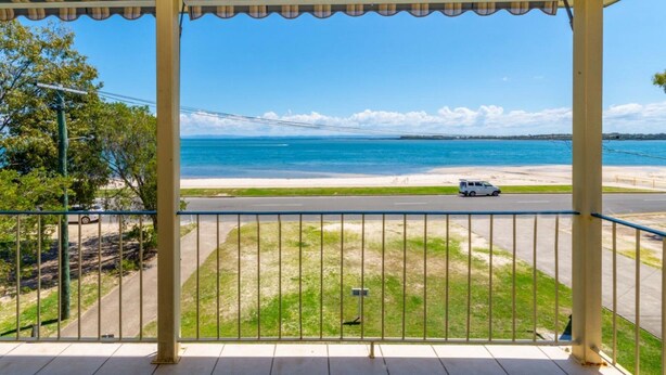 Un balcon avec vue sur une plage et l’océan.