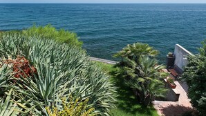 A coastal view with a balcony overlooking the sea, surrounded by lush greenery and a bench. - Holiday apartment with sea access on the Ionian Coast, Sicily (Torre Archirafi)