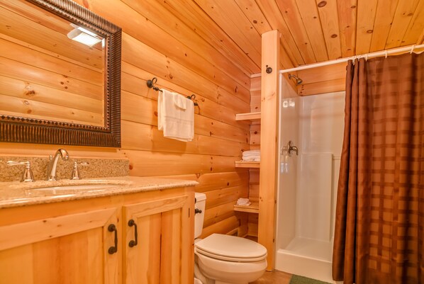 A wooden cabin bathroom with a sink, toilet, and shower. - Piney Knob Lodge-15 Min to Lake Lure-30 Min to TIEC-Hot Tub -Stocked Pond-Creek (Rutherfordton)
