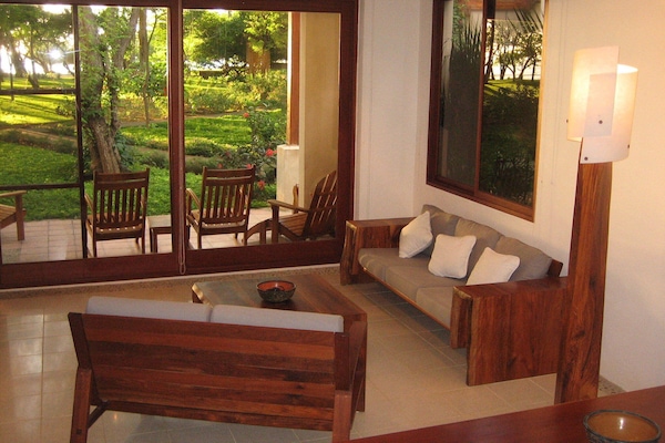 Living area showing the natural light of the end unit and the patio facing ocean