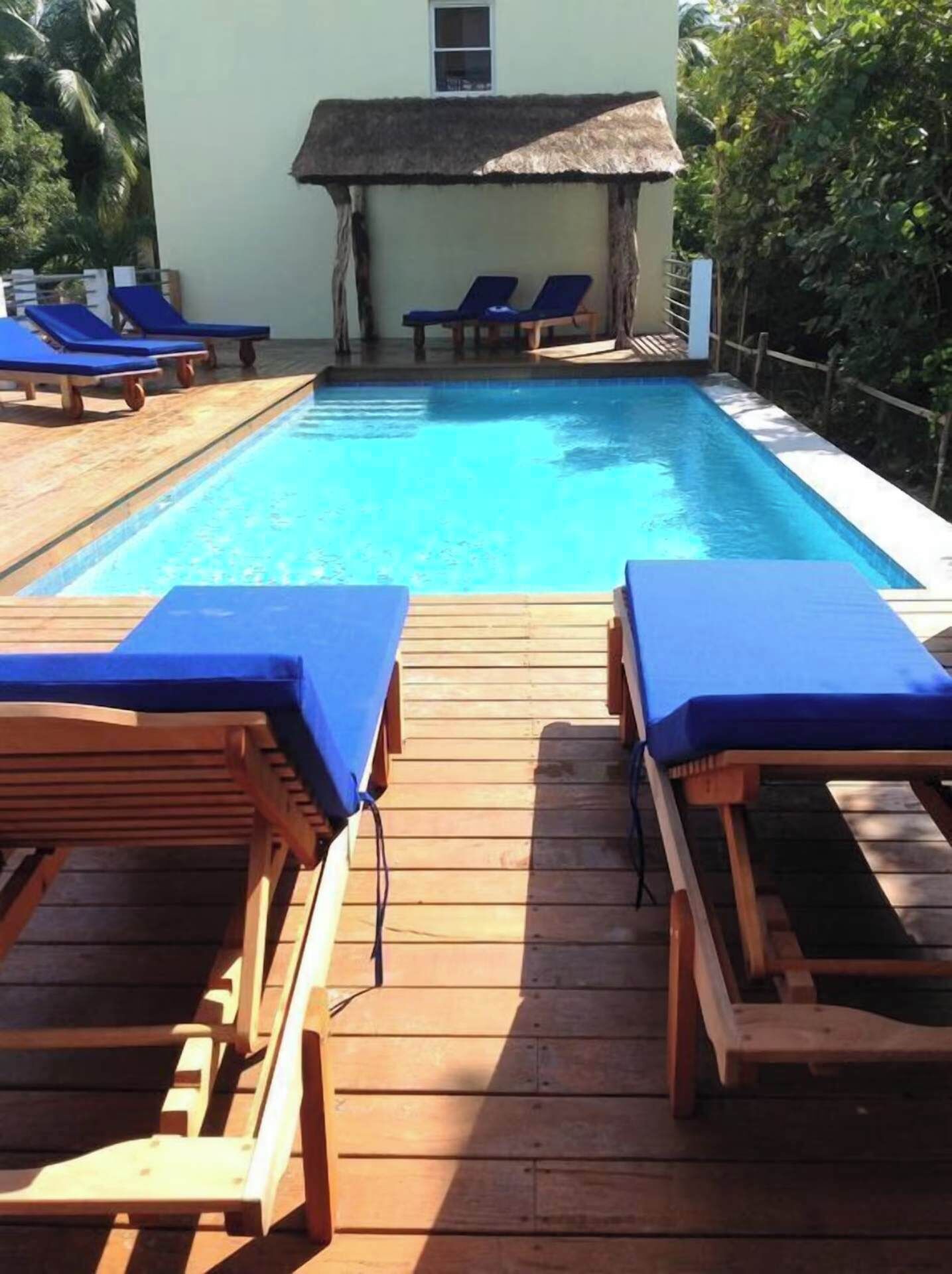A pool area with wooden deck and lounge chairs.